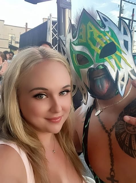 Amy Damjanovic with a masked wrestler